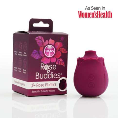 A burgundy, rose-shaped personal care product with buttons, called the Skins Rose Buddies-The Rose Flutters, is displayed next to its packaging. The box showcases a floral design and branding, with the text "As Seen In Women's Health" appearing in the top