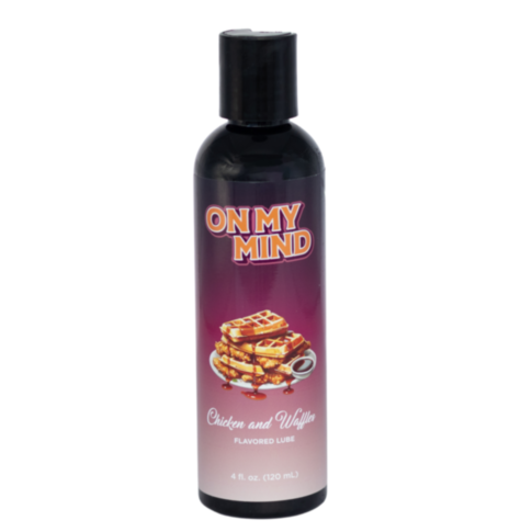 A 4 oz bottle of On My Mind-Chicken and Waffles flavored lube stands against a white background. The black bottle with a pop-up cap promises lasting moisture, ensuring safe daily use. Its unique flavor is depicted on the labels image.